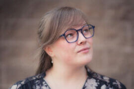 Young woman in glasses looking up