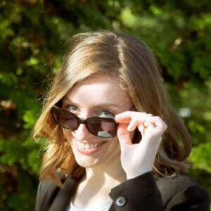 Young woman looking over sunglasses