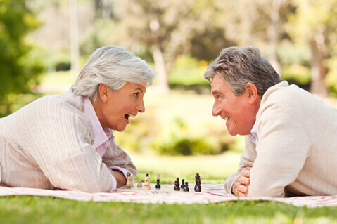 Older couple playing chess in park