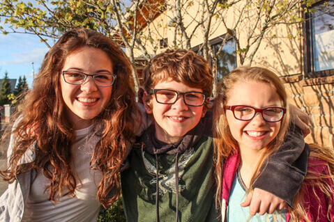 Three young friends wearing glasses