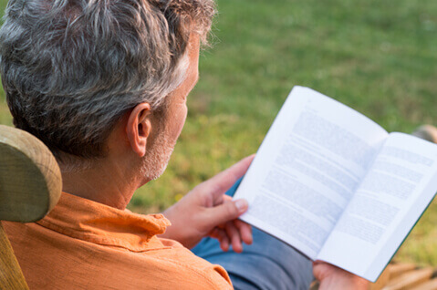 Man reading book outside