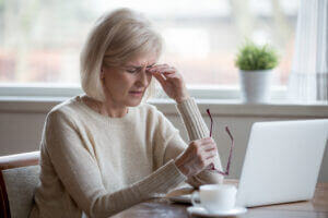 Woman rubbing her dry eyes