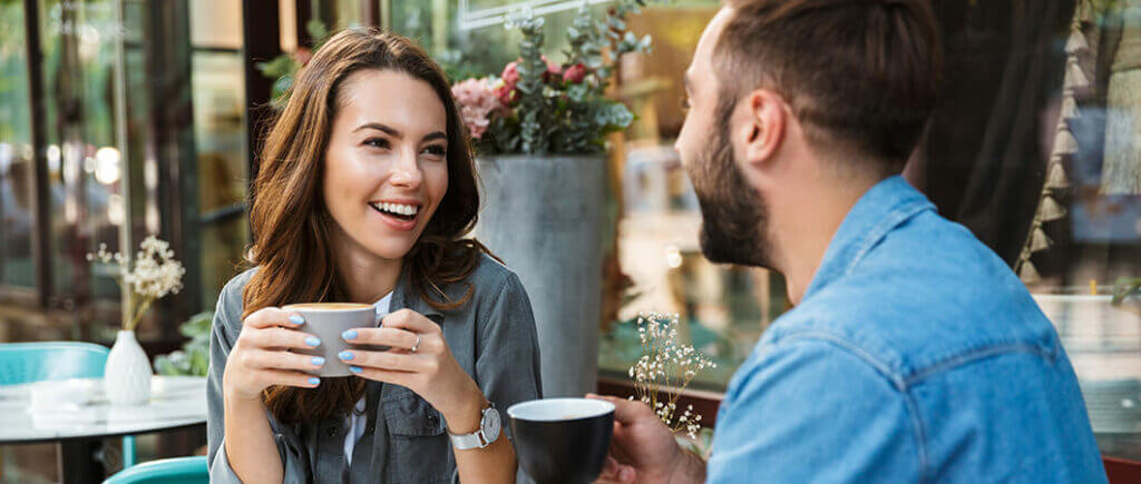 Young couple having coffee outside without wearing eyeglasses